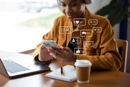 african-woman-typing-smartphone-keyboard-with-laptop-computer-ofxa-social-media-marketing-virtual-icons-screen-concept